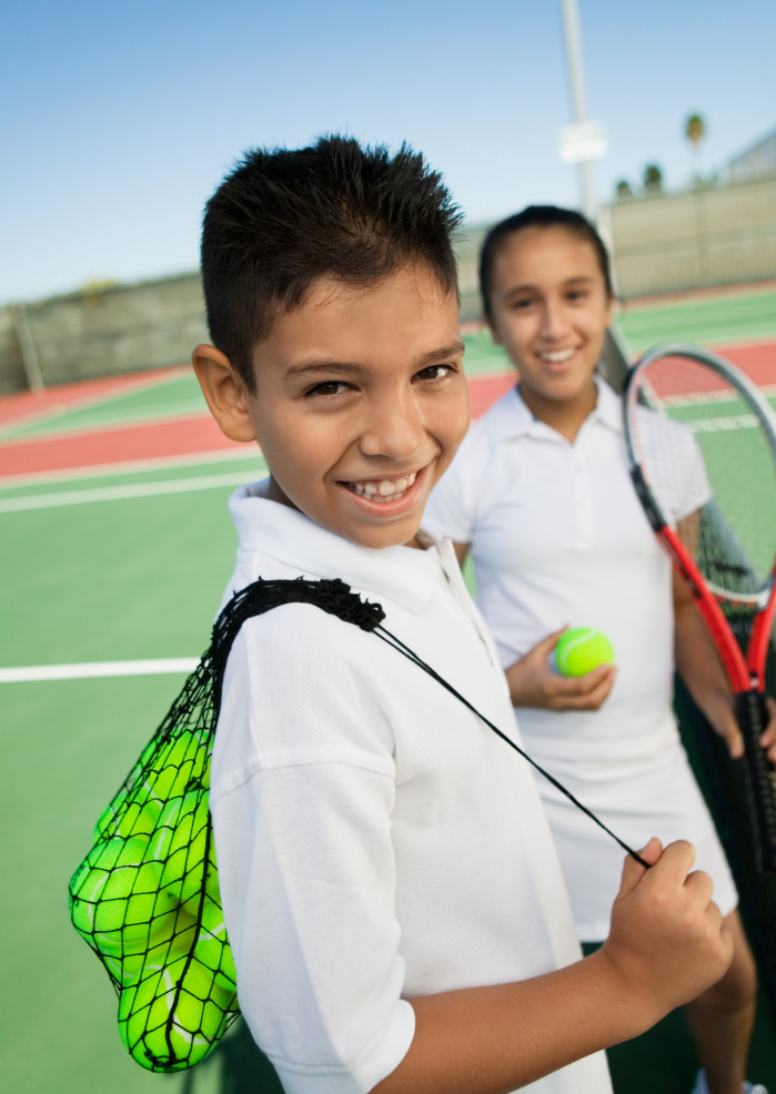children carrying their tennis equipment